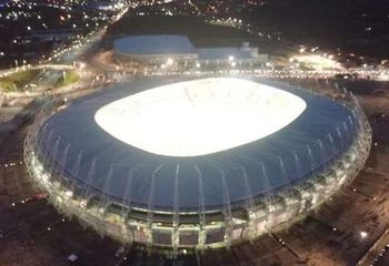 Vista aérea da Arena Castelão em Fortaleza - CE iluminada durante a noite.